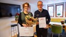 Sofie Rotstedt och Nils-Erik Andersson, ledamot och ordförande i styrelsen för Ödestugu sockenråd, står uppställda och visar upp blommor och diplom för folkhälsopriset.