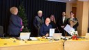 tre kvinnor och två män står upp bakom en man som sitter ner bakom ett konferensbord under utdelningen av folkhälsopriset på regionfullmäktige.