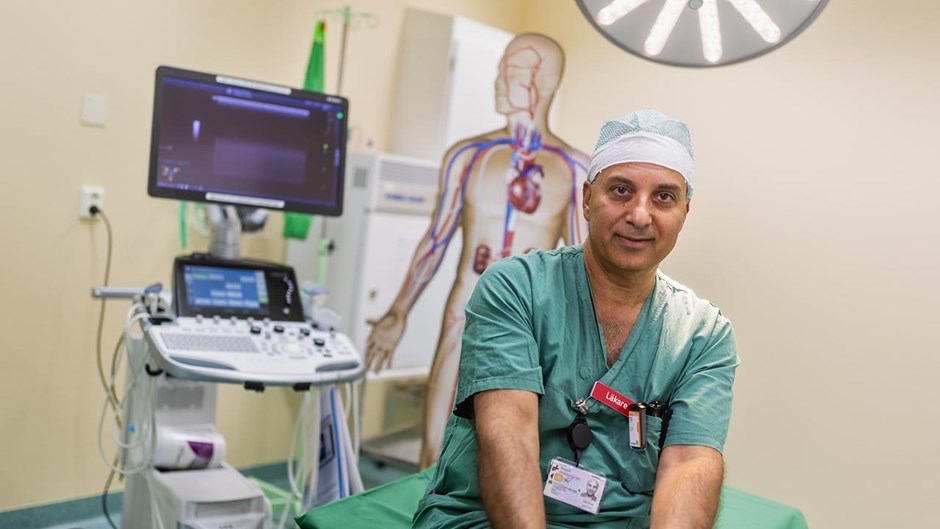 Man i operationskläder sitter i ett rum på ett sjukhus