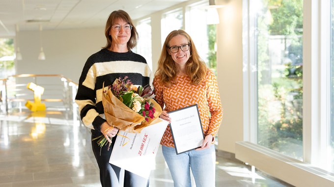 Två kvinnor tittar in i kameran och ler.