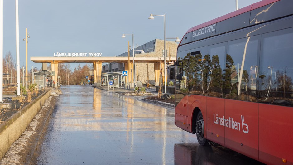 Röd buss som åker mot den nya huvudentrén på Länssjukhuset Ryhov i Jönköping.