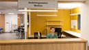 En person i gröna kläder sitter vid en reception.