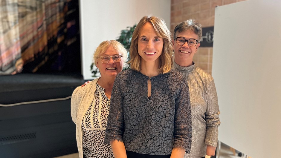 Karin Winther står tillsammans med huvudhandledare och examinator inne i aulan på Ryhov.