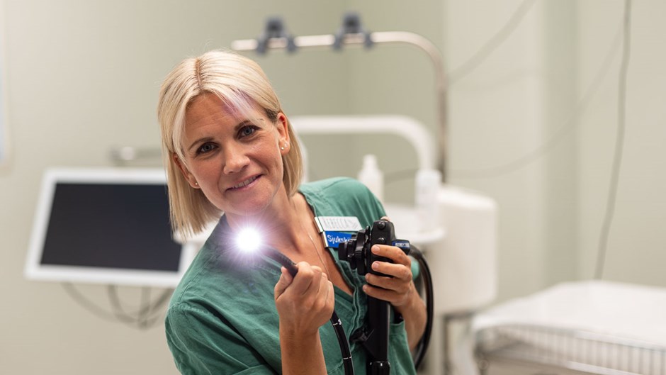 Medarbetare i vårdmiljö håller ett medicintekniskt instrument med inbyggd ljuskälla i ett undersökningsrum.