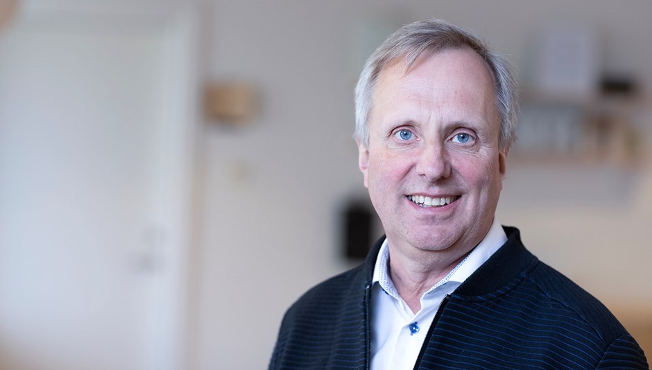 En man som ler in i kameran