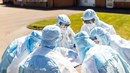 Flera personer i vårdkläder står i grupp och pratar.