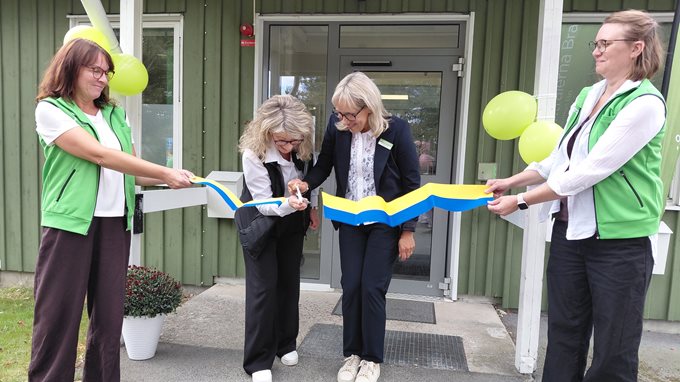 Två kvinnor klipper av ett band som två andra kvinnor håller i.