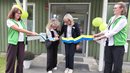 Två kvinnor klipper av ett band som två andra kvinnor håller i.