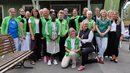 Många grönklädda medarbetare inom vården står i en grupp.