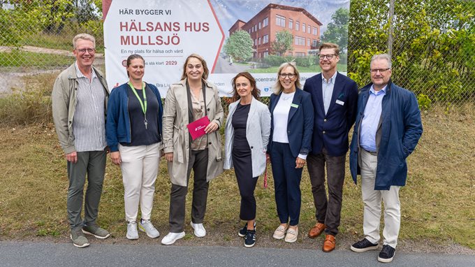 Sju personer uppställda vid ett stängsel.