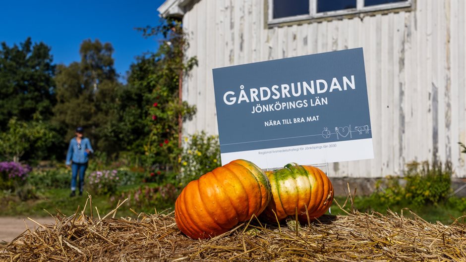 Två pumpor ligger framför en skylt om Gårdsrundan Jönköpings län.